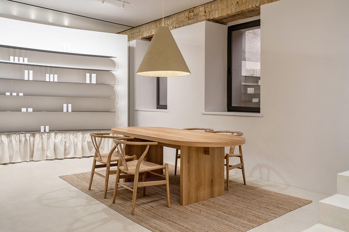 Tactile brick complements beige hues and mirrored surfaces for the interior of cosmetic showroom
