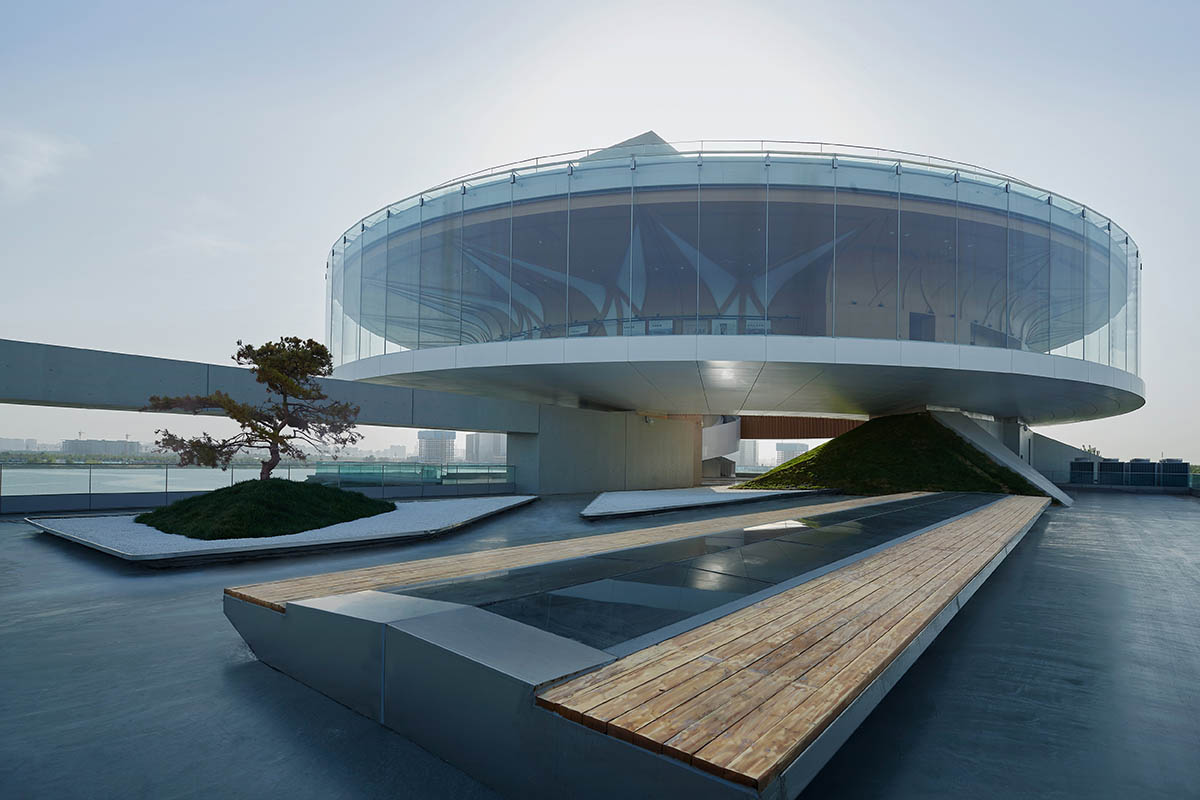 STUDIO A+ designs climbable ring-shaped art center on a green mound in Zhengzhou