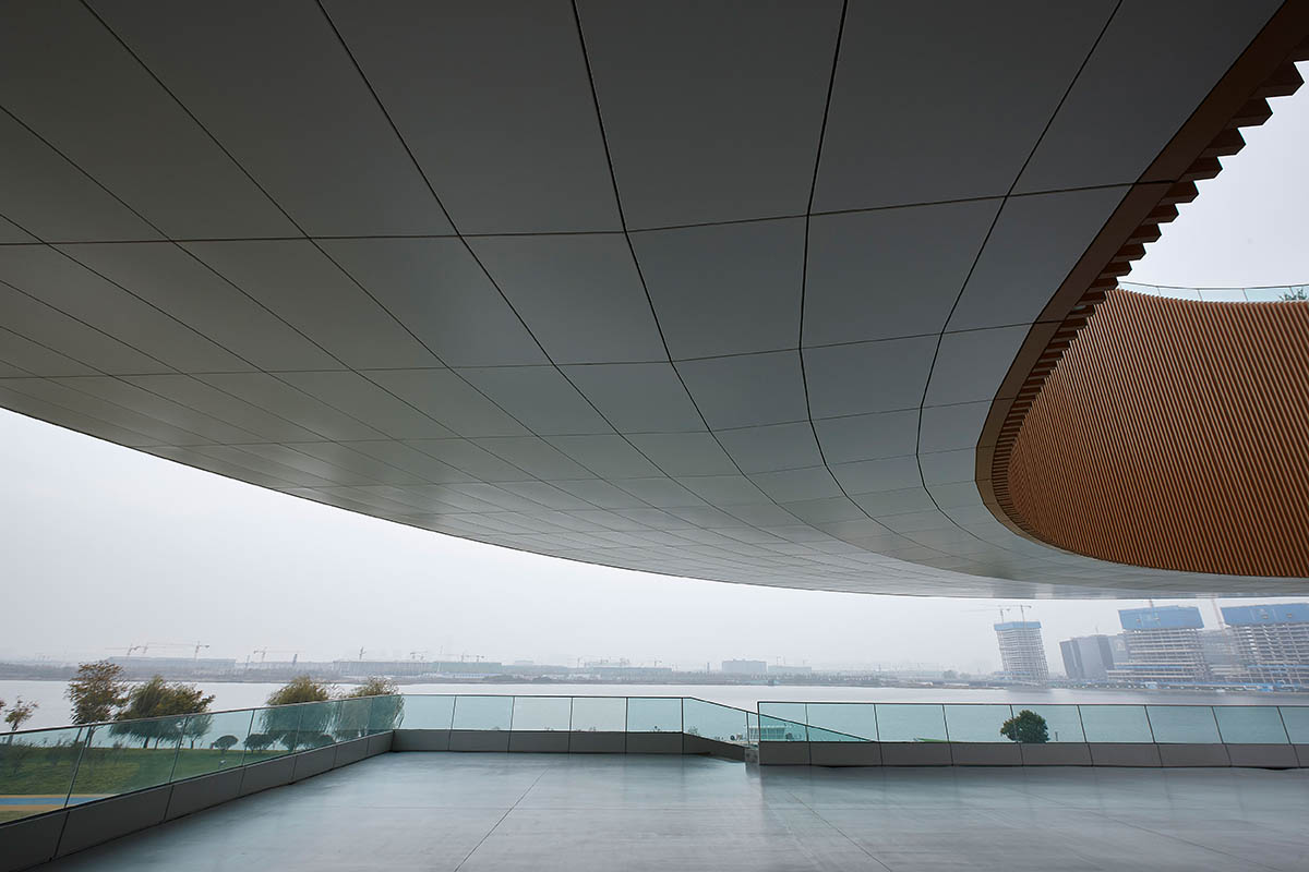 STUDIO A+ designs climbable ring-shaped art center on a green mound in Zhengzhou