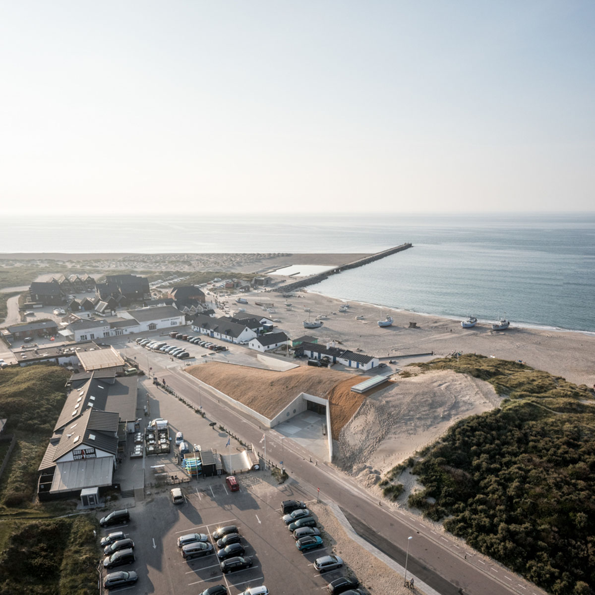 LOOP Architects embeds visitor center into existing dune landscape creating natural hill in Denmark 