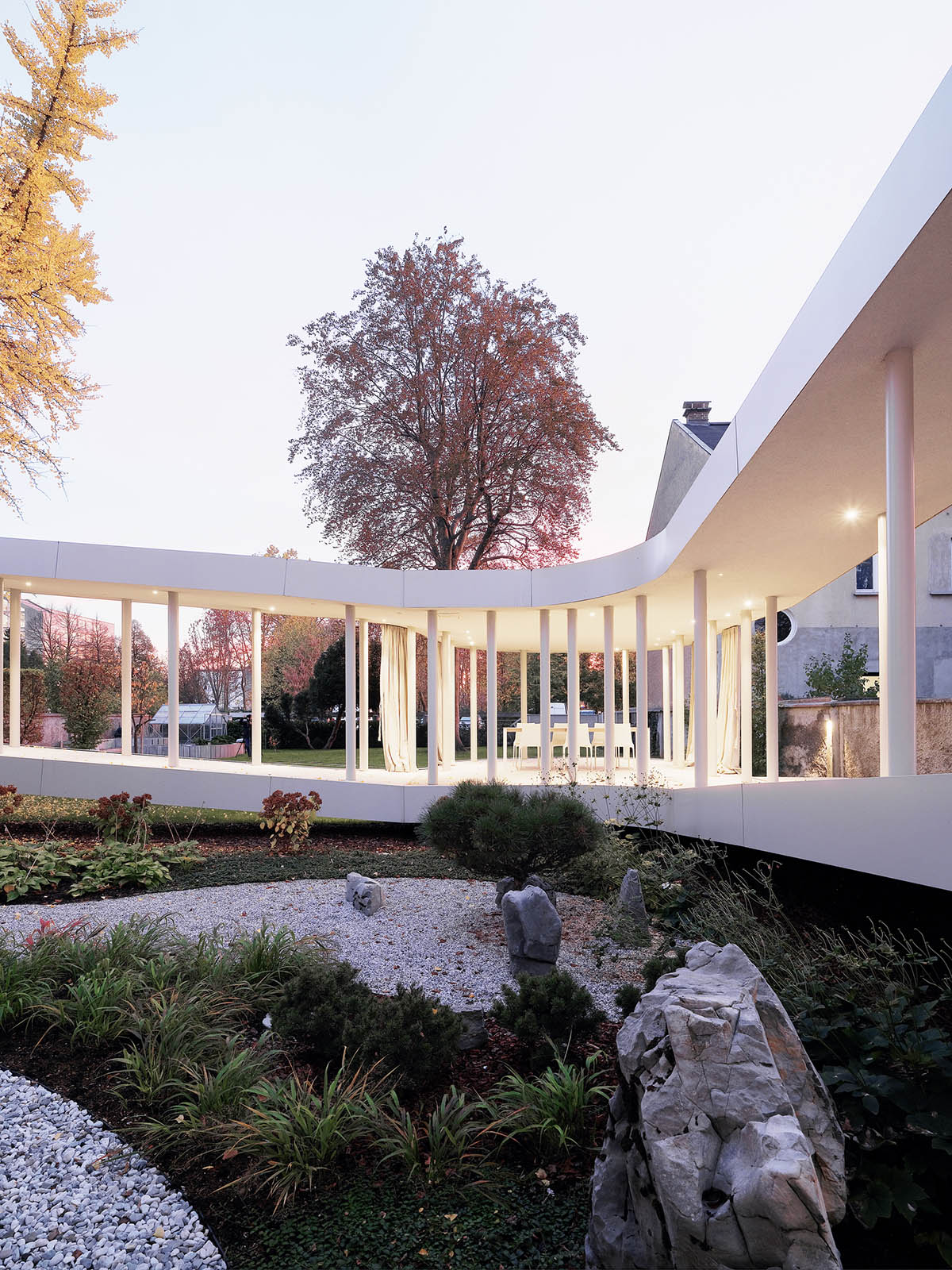 OFIS Architects renovates 1930s house with colonnaded and sloped pavilion in Slovenia 
