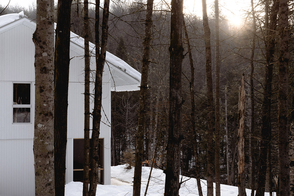 Canadian winter home designed by Atelier L'Abri looks like it is covered in  snow in the forest