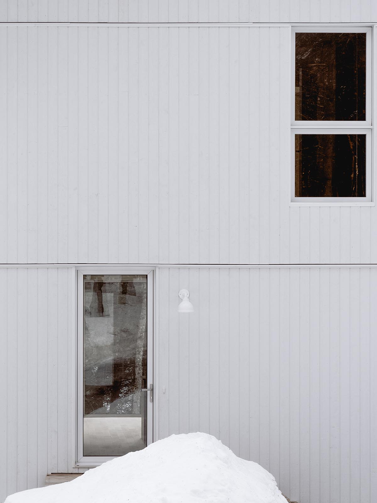 Canadian winter home designed by Atelier L'Abri looks like it is covered in  snow in the forest