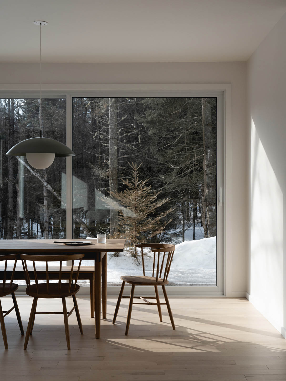 Canadian winter home designed by Atelier L'Abri looks like it is covered in  snow in the forest