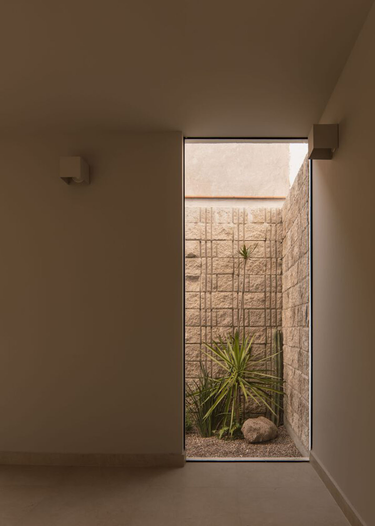 Теплые бежевые тона смягчают жесткие линии дома Enigma House, спроектированного MEM Arquitectos.