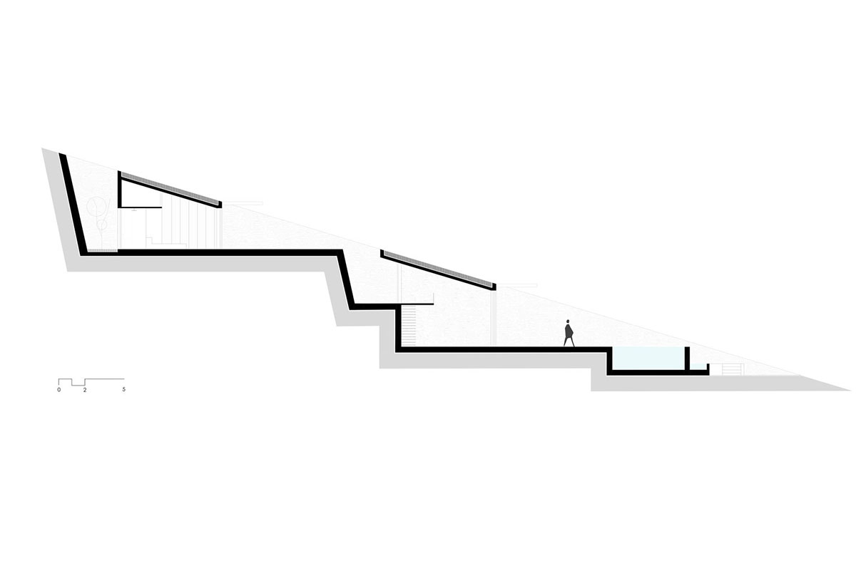 MOLD Architects used advantages of sloping land to design Ncaved house in Greece