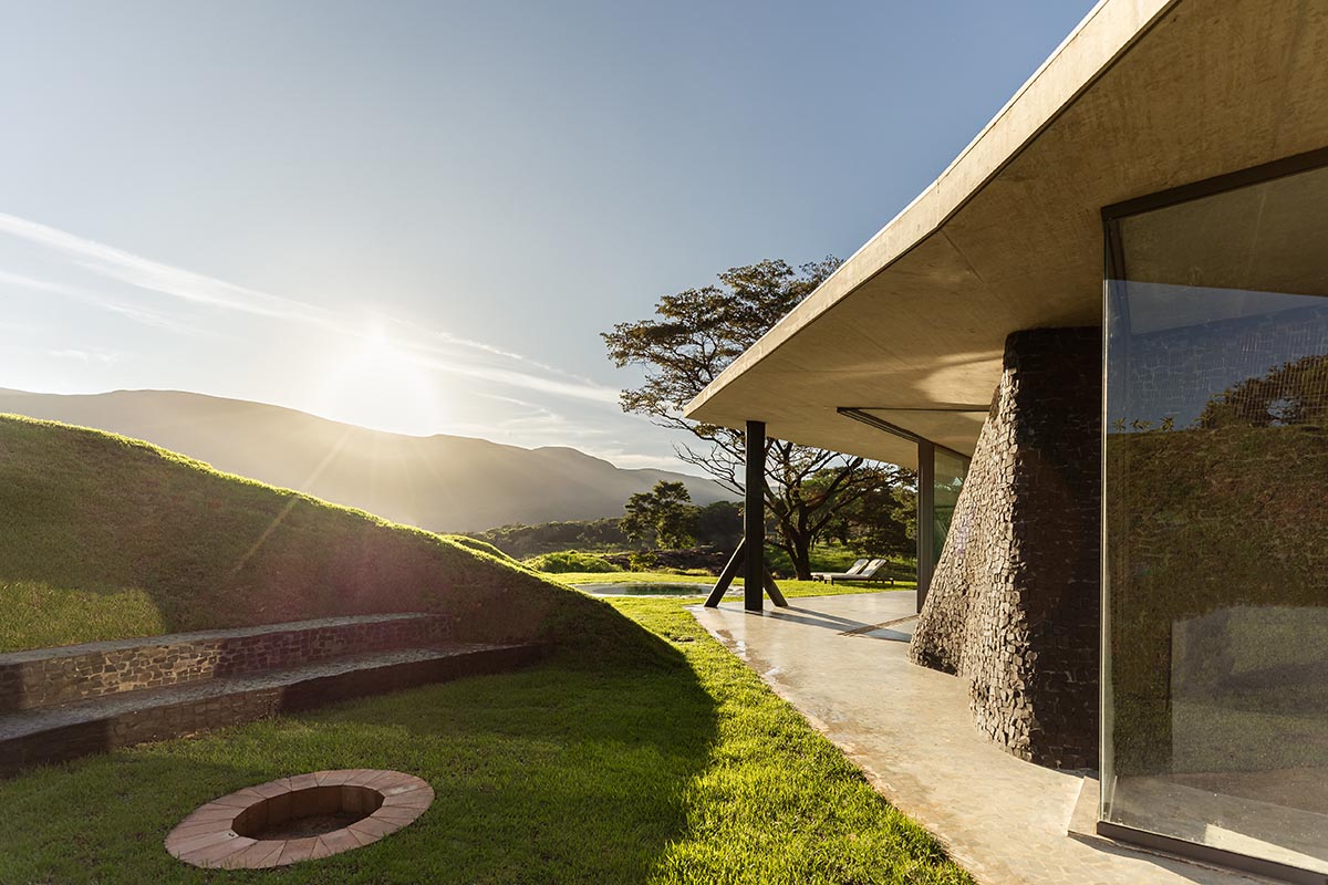 Seriema House is shaped around massive, black Portuguese stones for contemplation in Brazil