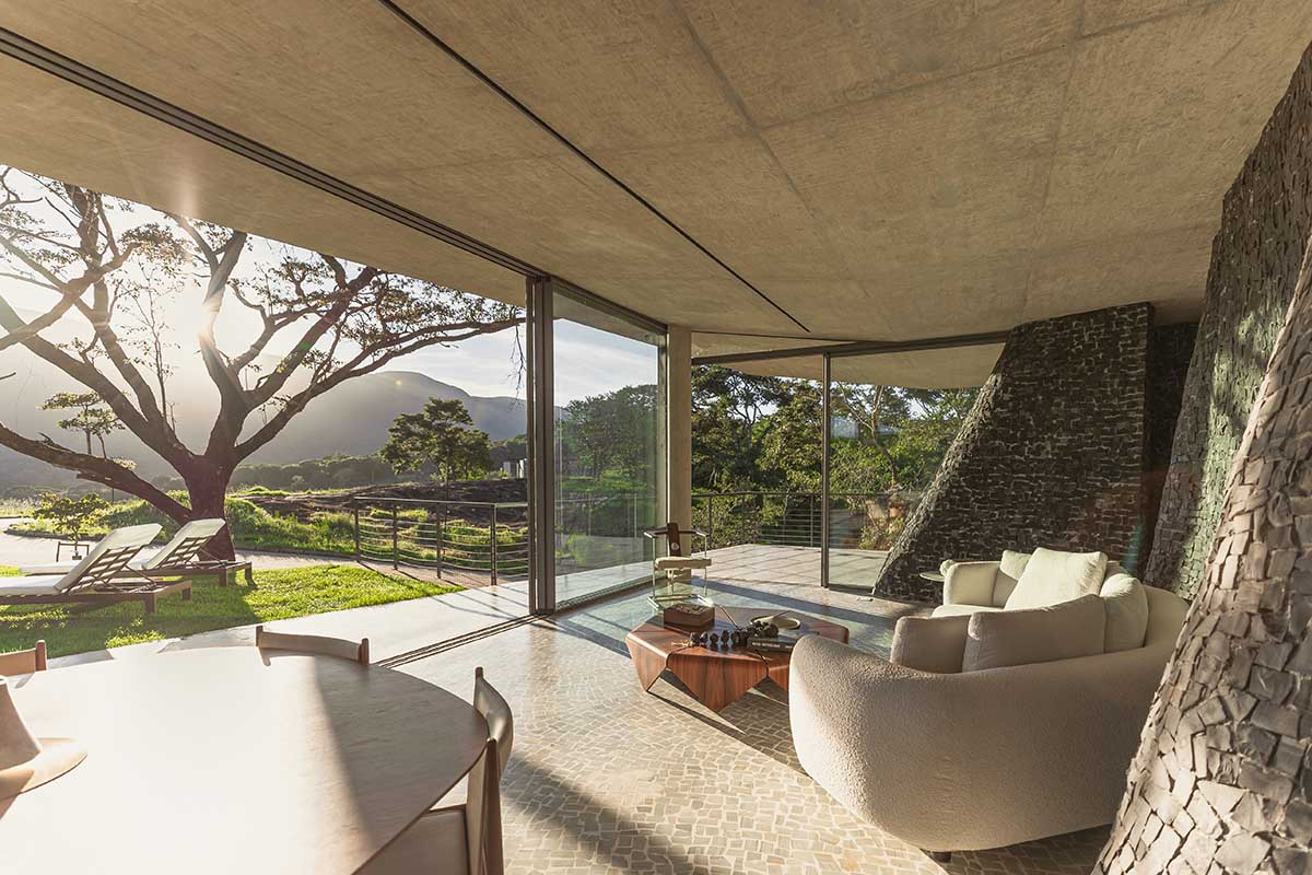 Seriema House is shaped around massive, black Portuguese stones for contemplation in Brazil