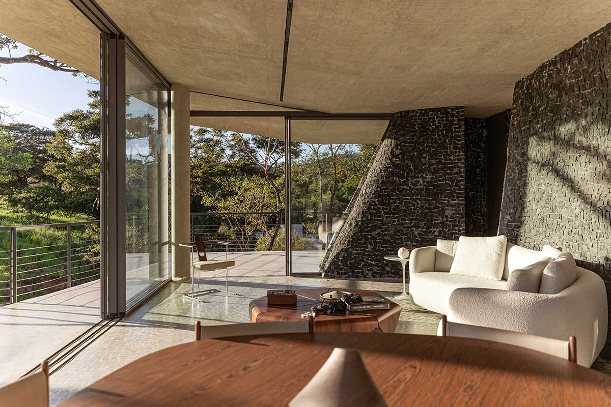 Seriema House is shaped around massive, black Portuguese stones for contemplation in Brazil