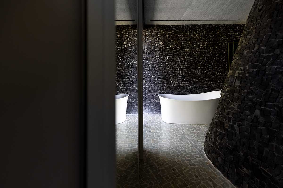 Seriema House is shaped around massive, black Portuguese stones for contemplation in Brazil