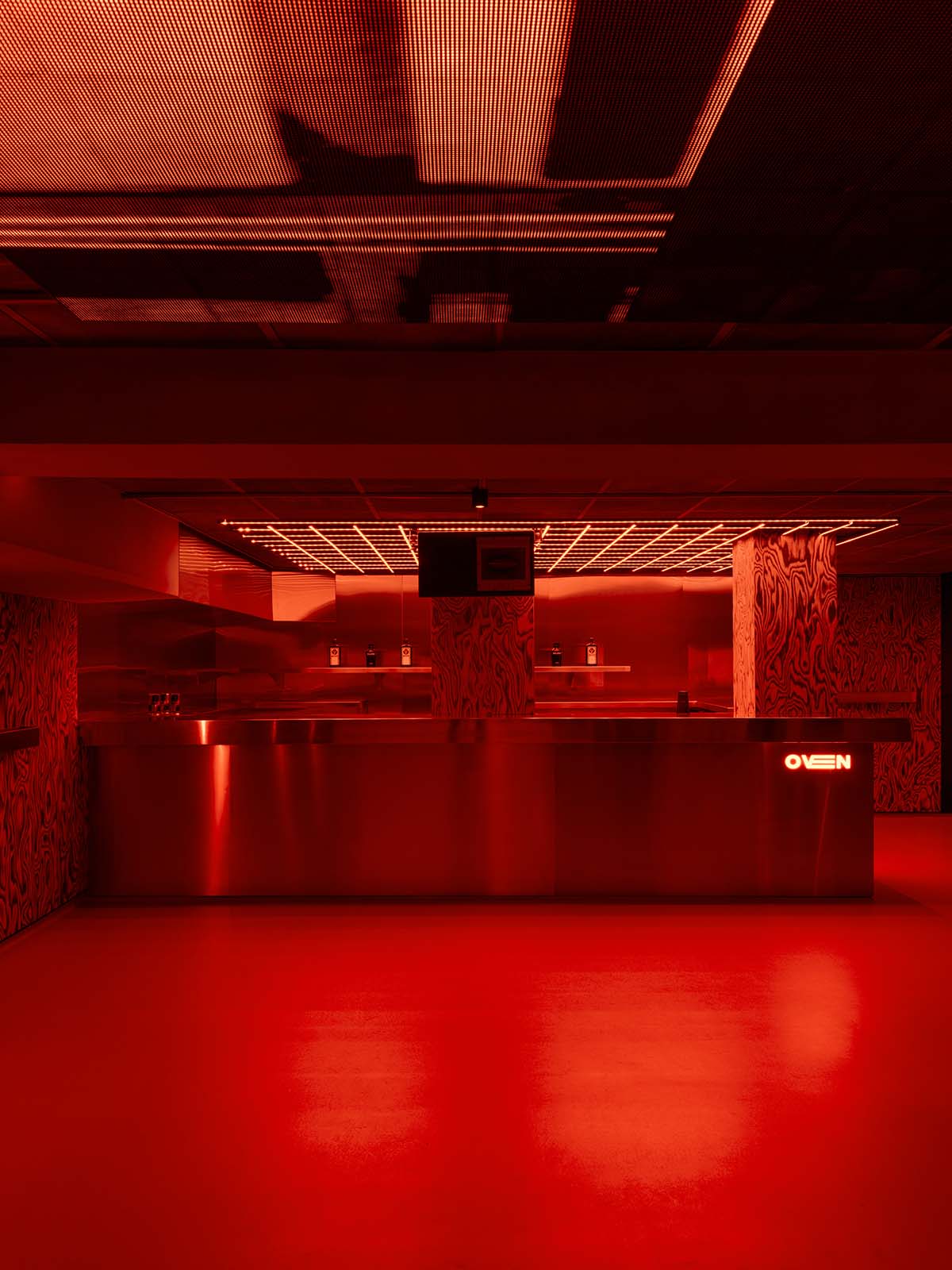 Bold red and black surfaces dominate the interior of the Oven Club, designed by Clap Studio
