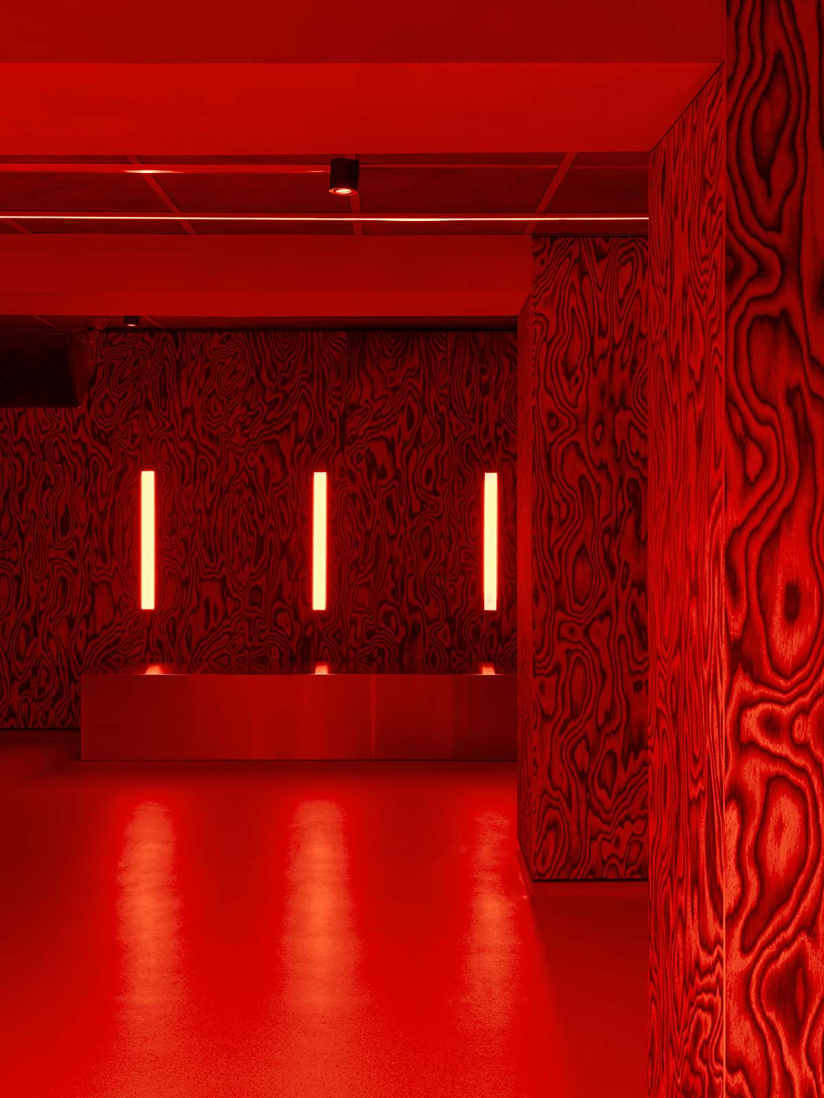Bold red and black surfaces dominate the interior of the Oven Club, designed by Clap Studio