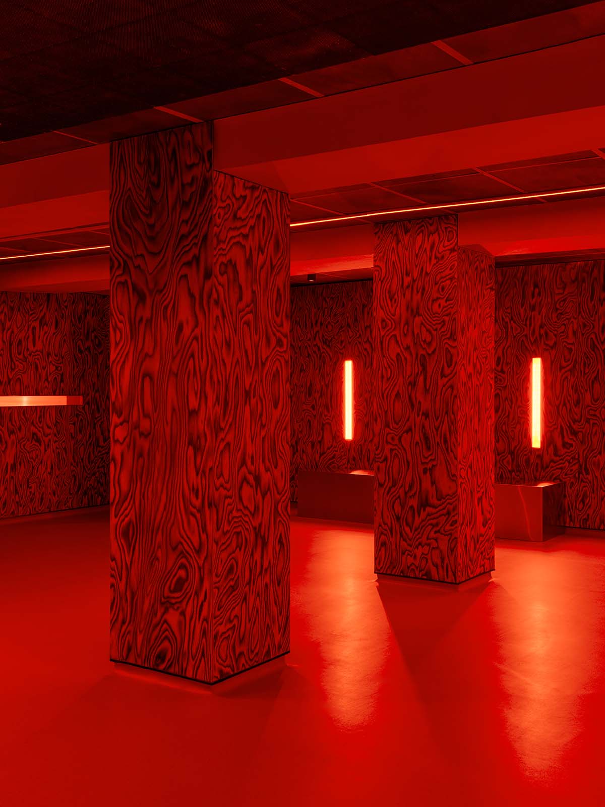 Bold red and black surfaces dominate the interior of the Oven Club, designed by Clap Studio