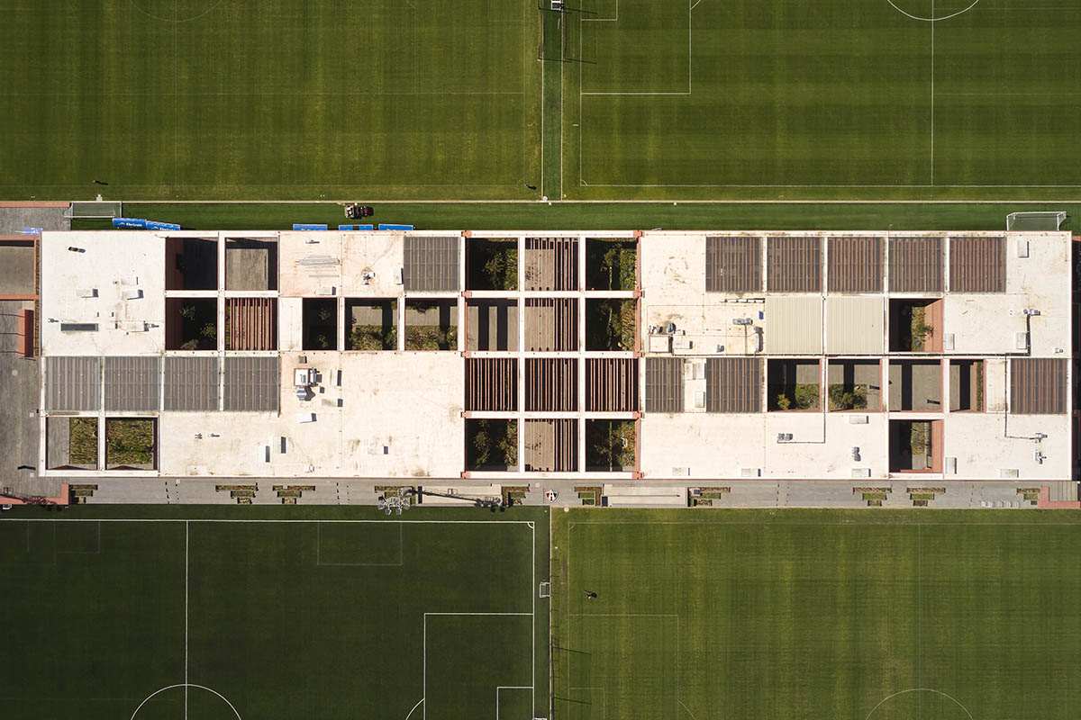 Red pigmented gridded structure defines village-like Mexican sport facility by Sordo Madaleno