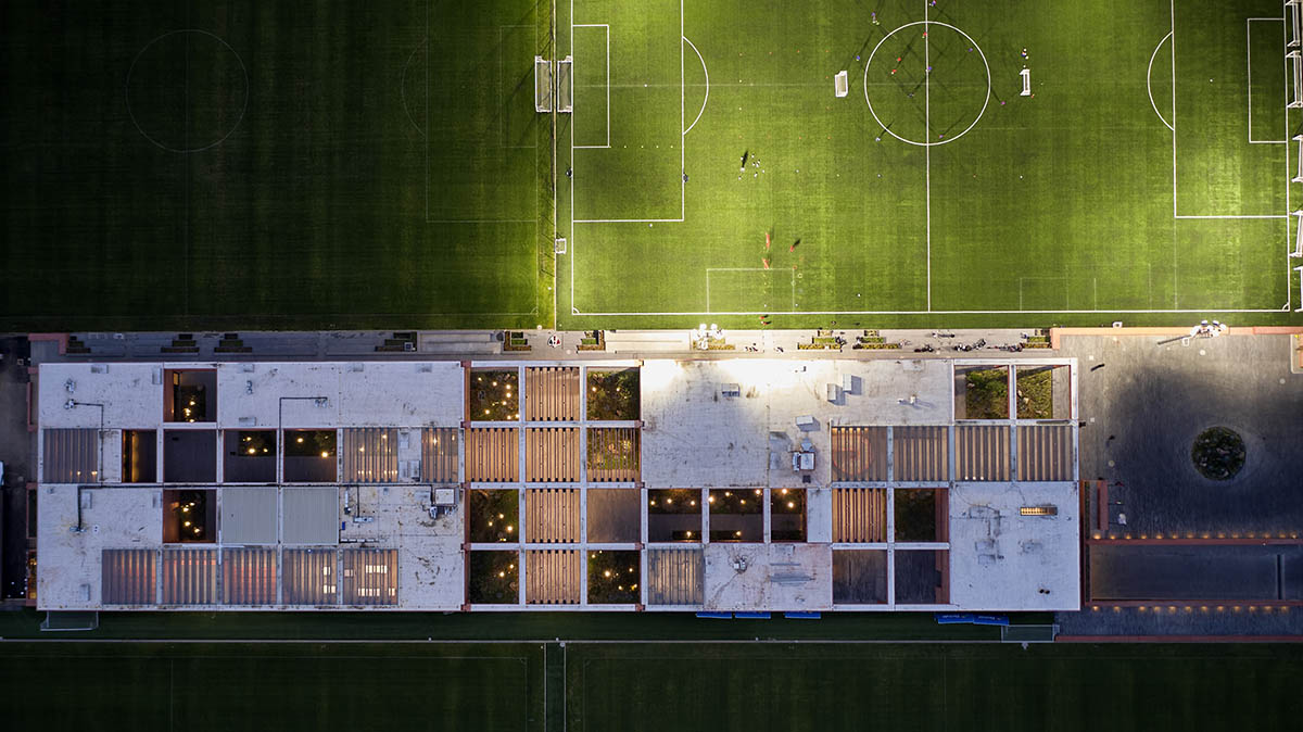 Red pigmented gridded structure defines village-like Mexican sport facility by Sordo Madaleno