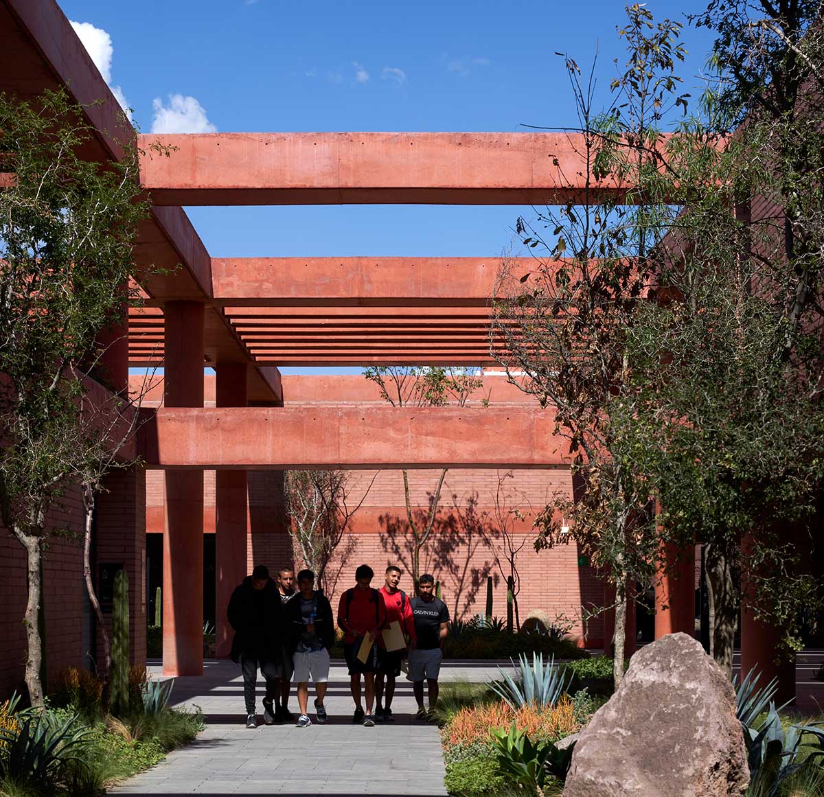 Red pigmented gridded structure defines village-like Mexican sport facility by Sordo Madaleno