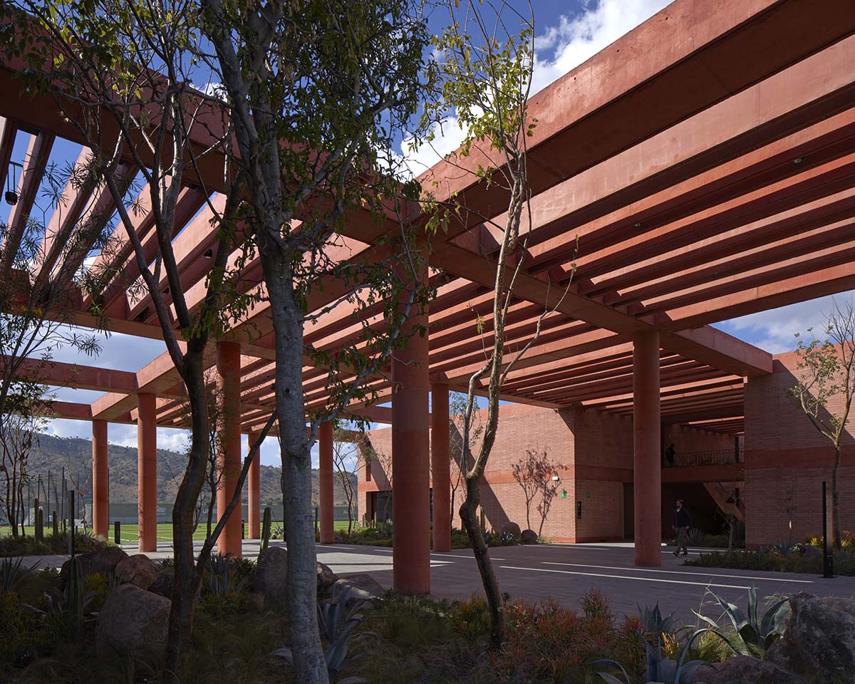Red pigmented gridded structure defines village-like Mexican sport facility by Sordo Madaleno