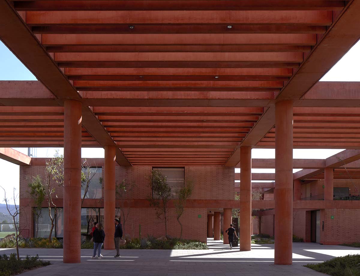 Red pigmented gridded structure defines village-like Mexican sport facility by Sordo Madaleno