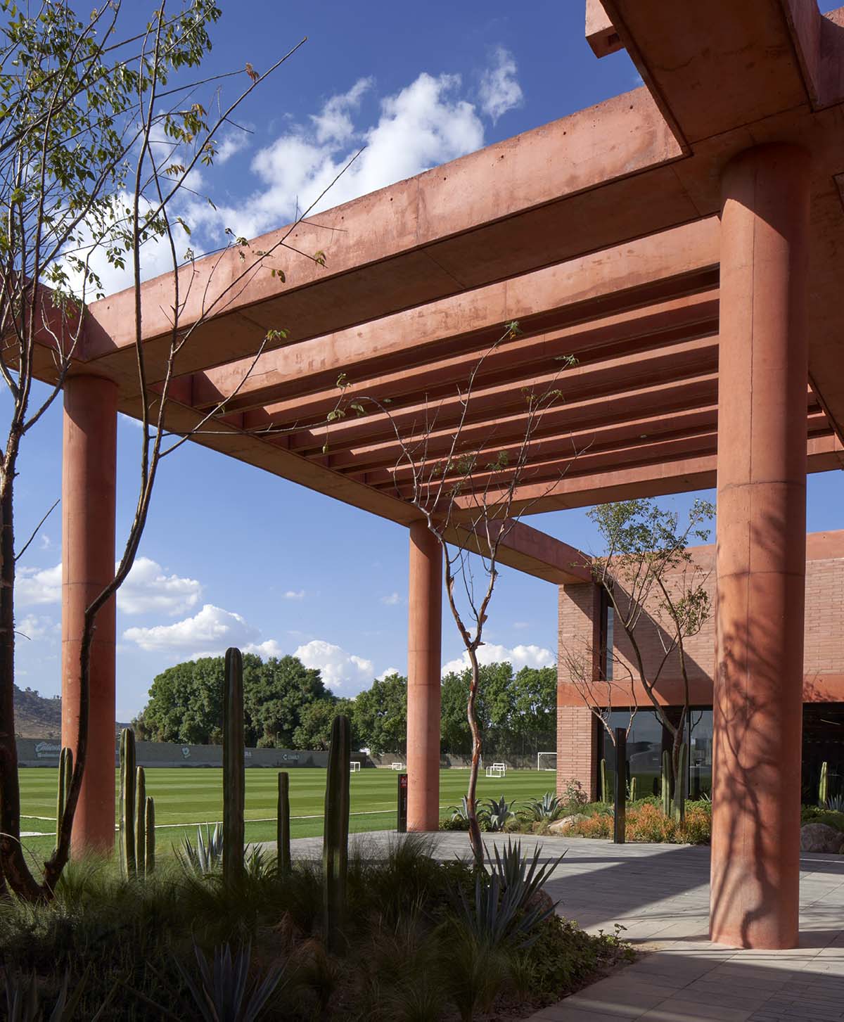 Red pigmented gridded structure defines village-like Mexican sport facility by Sordo Madaleno