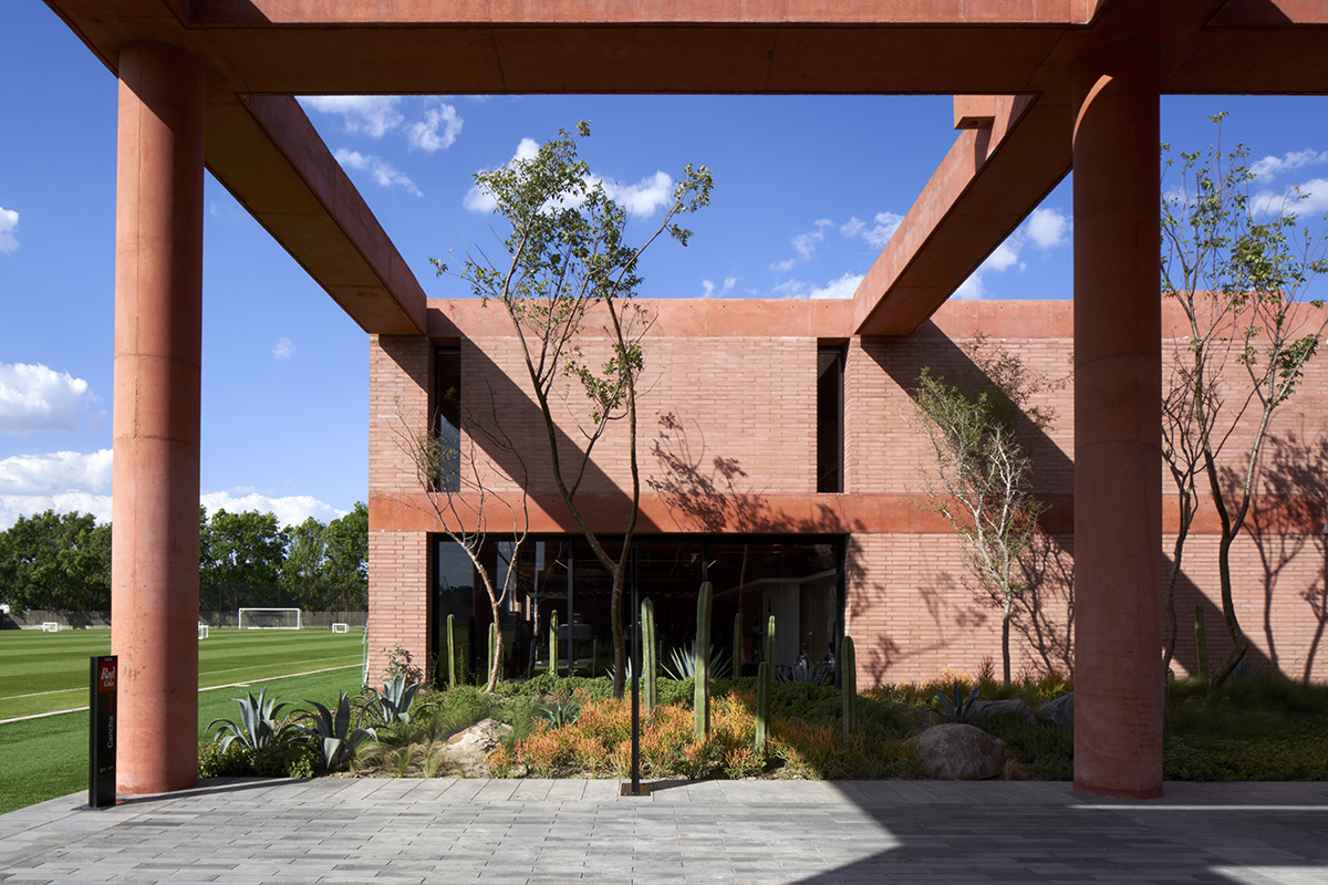Red pigmented gridded structure defines village-like Mexican sport facility by Sordo Madaleno