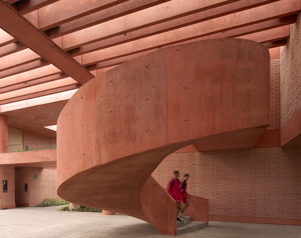 Red pigmented gridded structure defines village-like Mexican sport facility by Sordo Madaleno