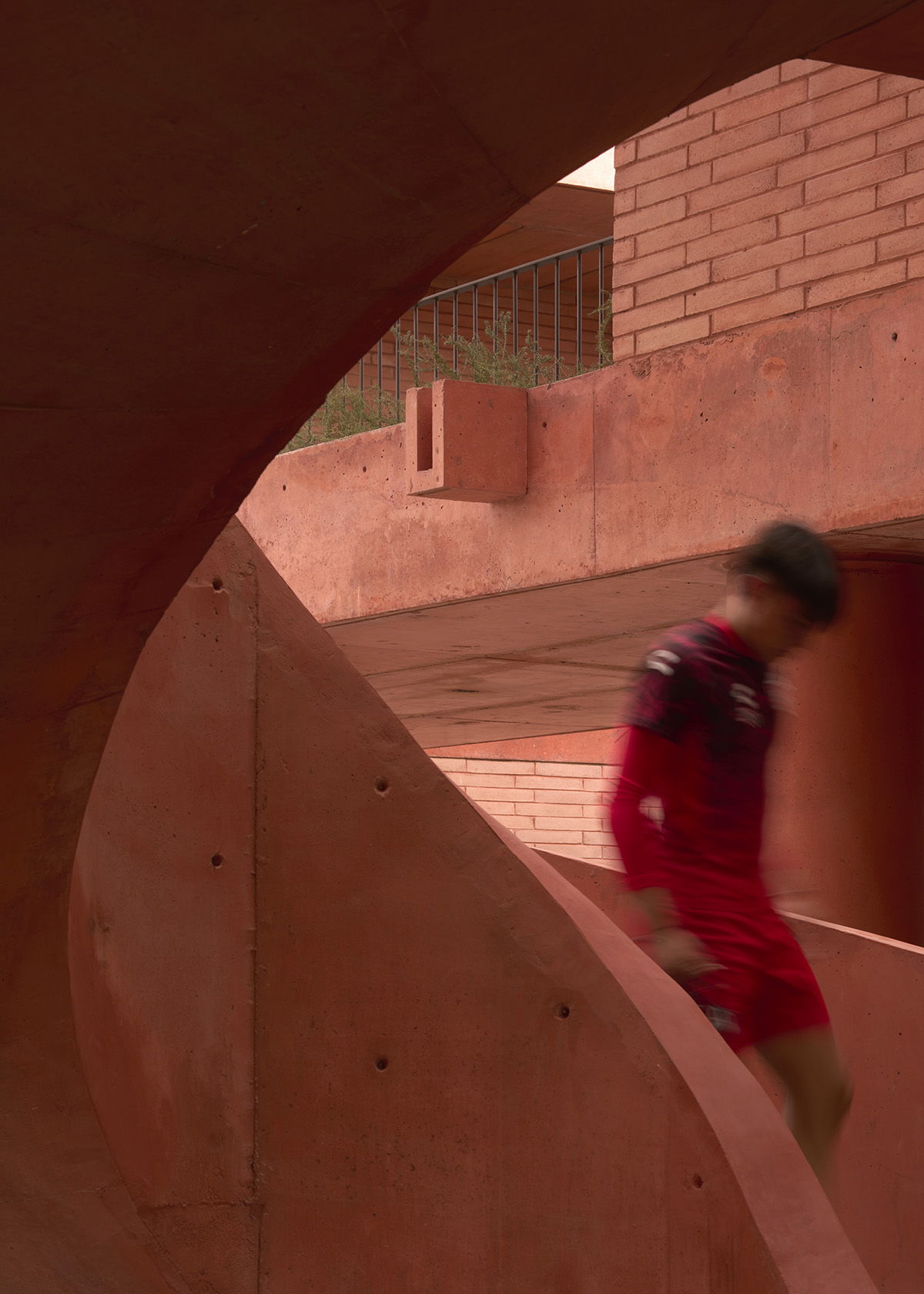 Red pigmented gridded structure defines village-like Mexican sport facility by Sordo Madaleno