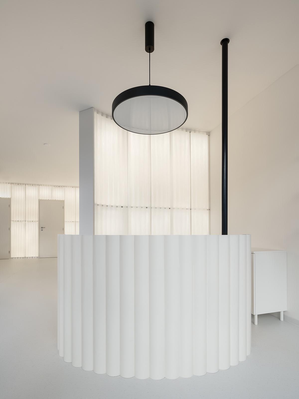 A beauty salon brings warm light with translucent partitions and tactile elements in Prague