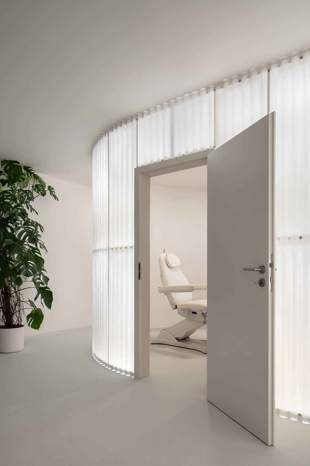 A beauty salon brings warm light with translucent partitions and tactile elements in Prague