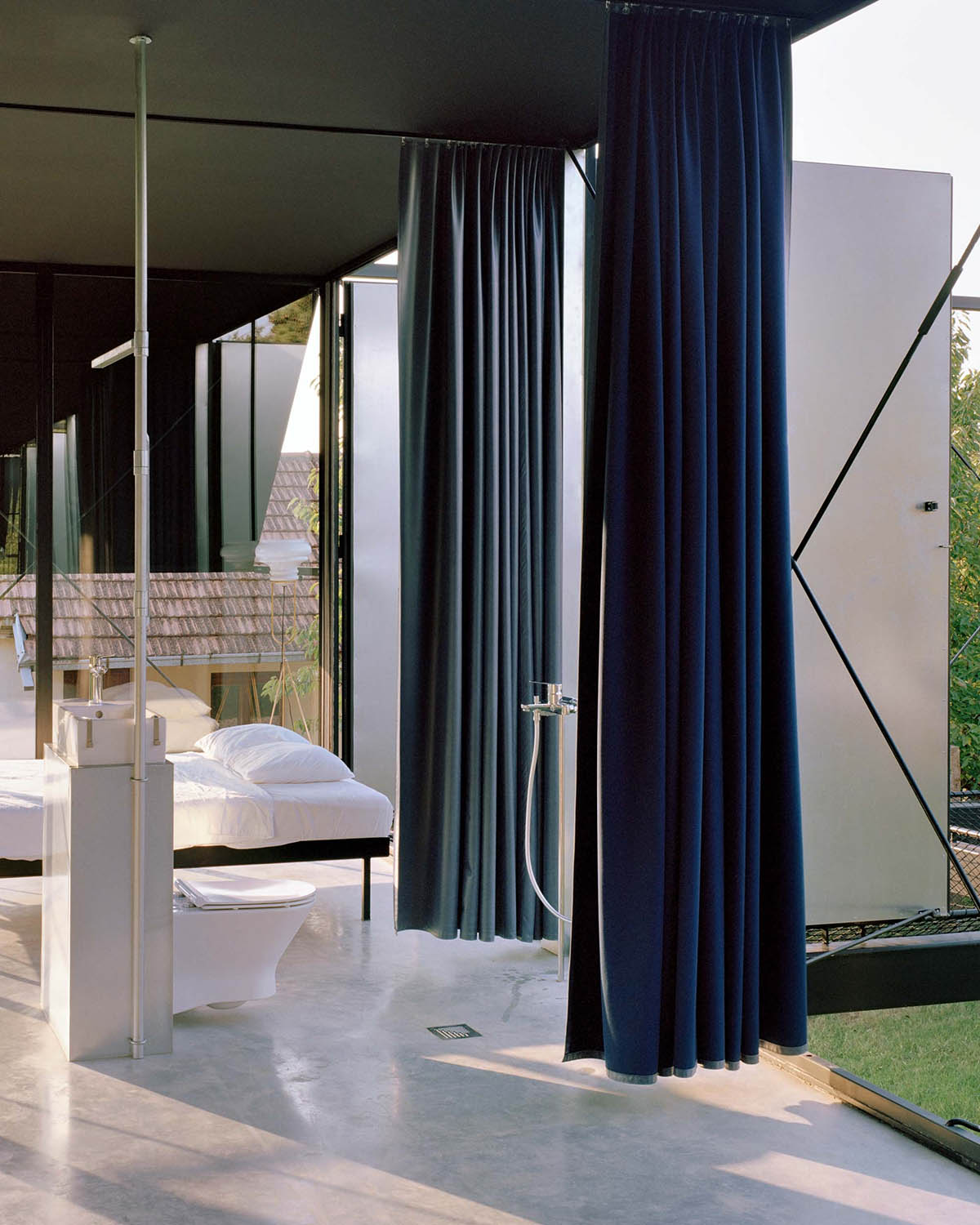 Avala House by TEN is a fully-glazed house supported by slope and triangular column in Belgrade