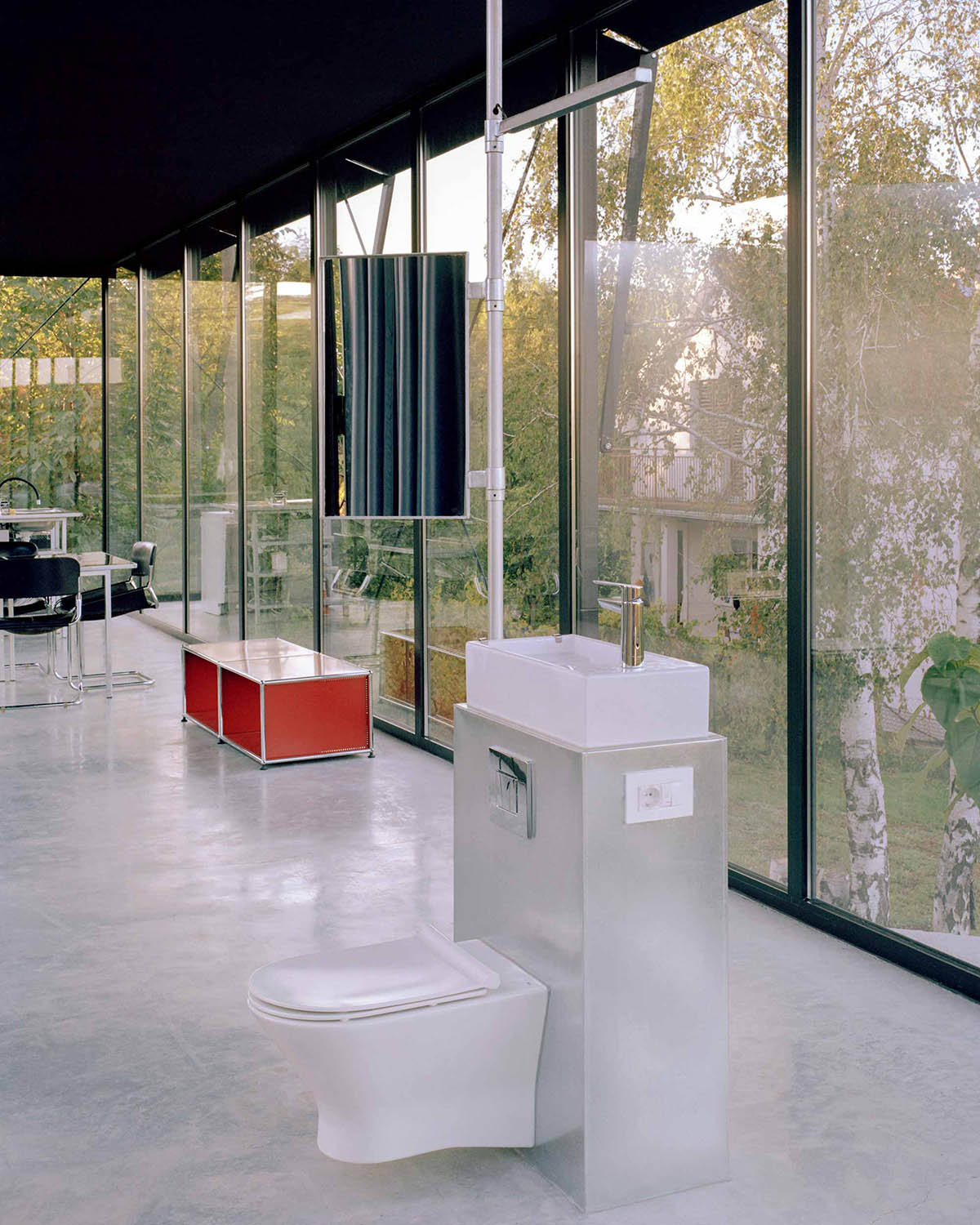 Avala House by TEN is a fully-glazed house supported by slope and triangular column in Belgrade