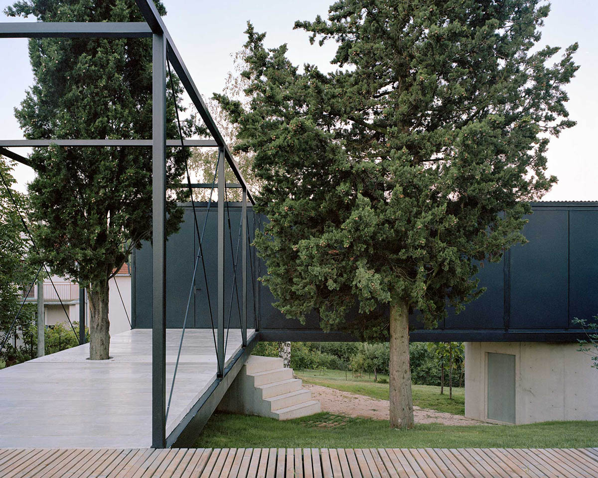 Avala House by TEN is a fully-glazed house supported by slope and triangular column in Belgrade