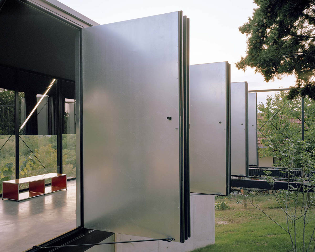 Avala House by TEN is a fully-glazed house supported by slope and triangular column in Belgrade