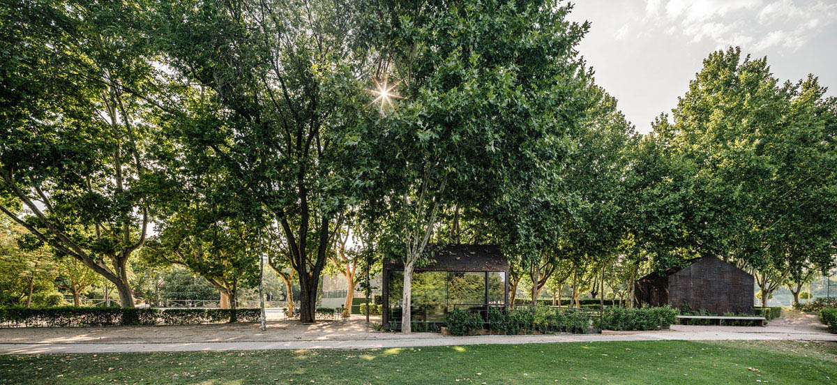 Beta.&Oslash; covers tennis and school buildings with varnished steel sheets and mesh to mimic the landscape