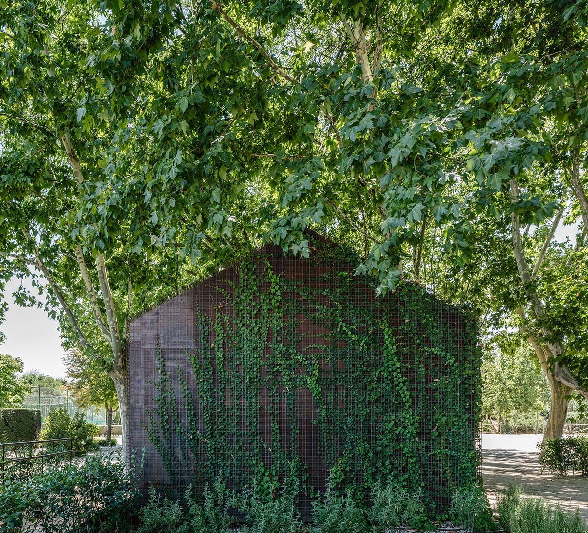 Beta.&Oslash; covers tennis and school buildings with varnished steel sheets and mesh to mimic the landscape