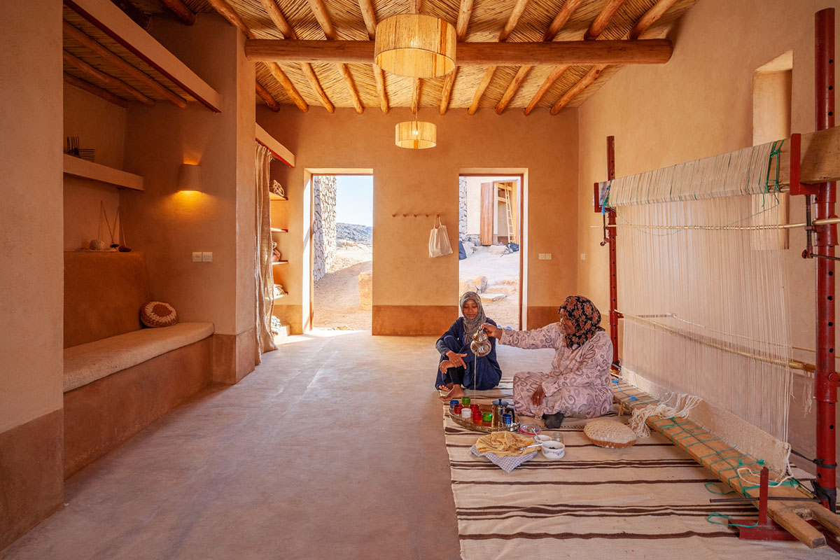 Two elongated walls made of granite rocks and earth form this women's house in a village of Morocco