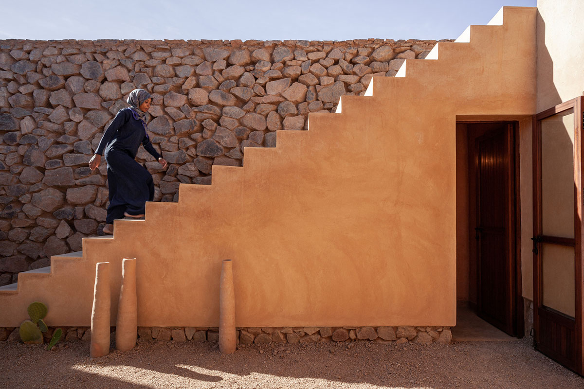 Two elongated walls made of granite rocks and earth form this women's house in a village of Morocco