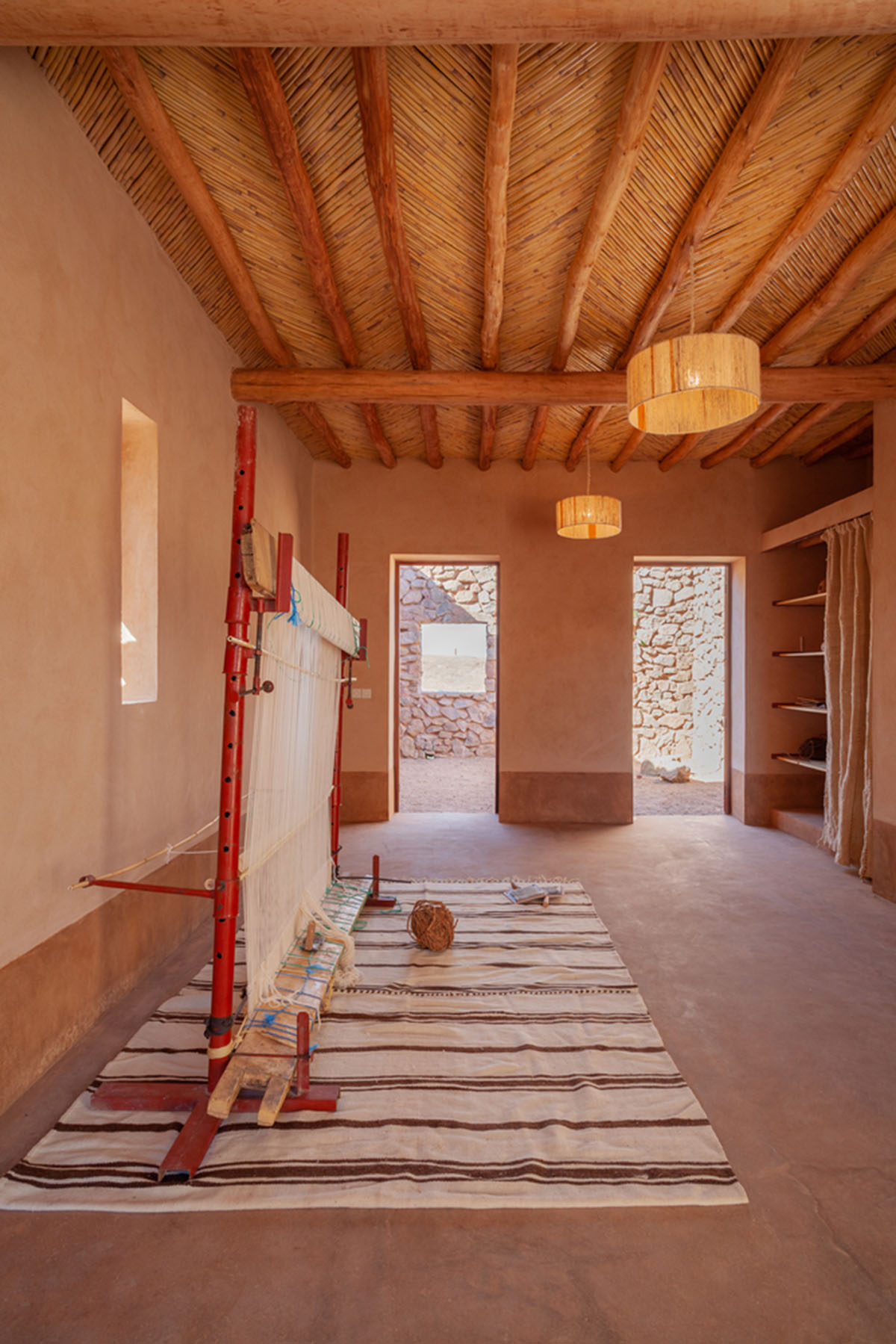 Two elongated walls made of granite rocks and earth form this women's house in a village of Morocco