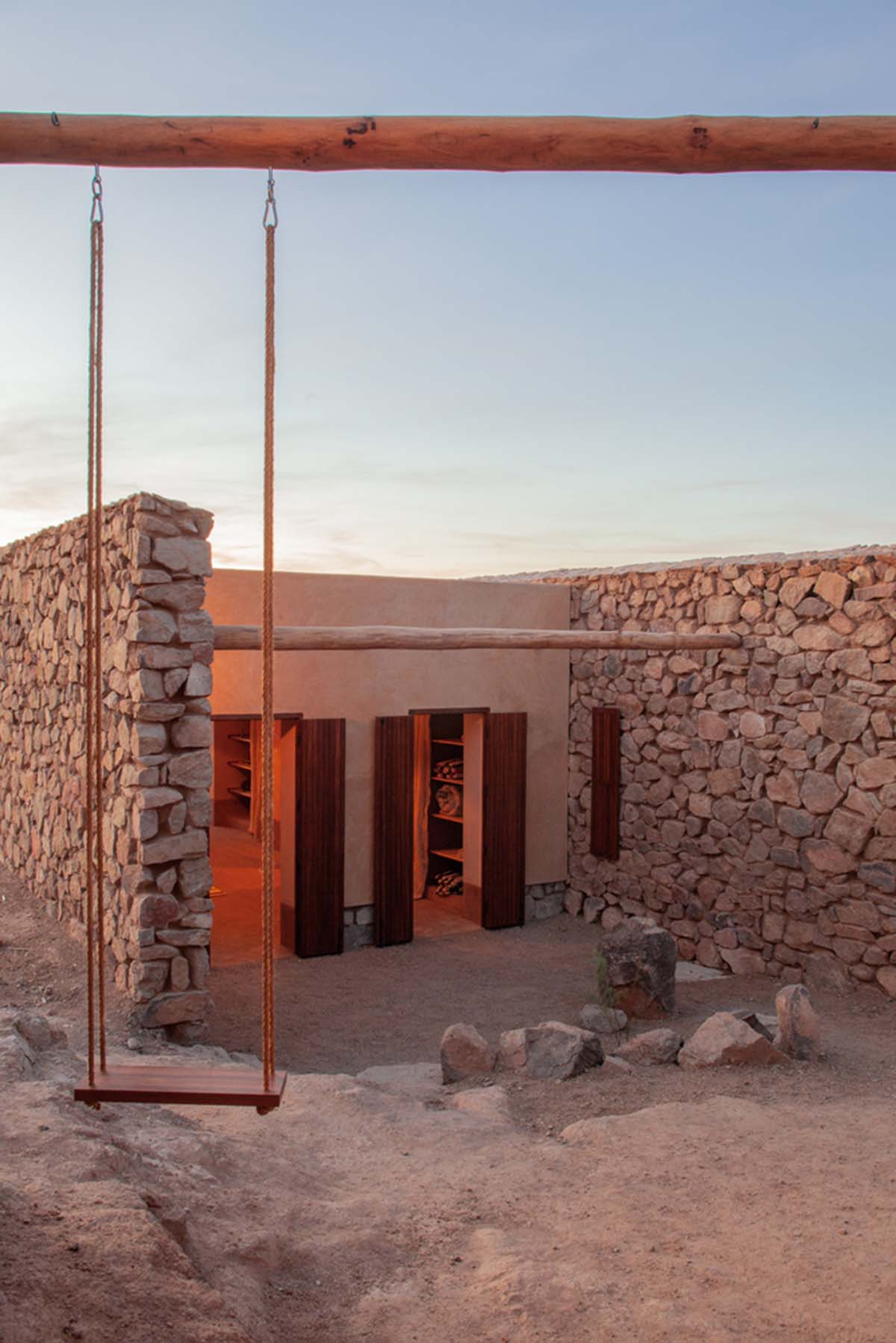 Two elongated walls made of granite rocks and earth form this women's house in a village of Morocco