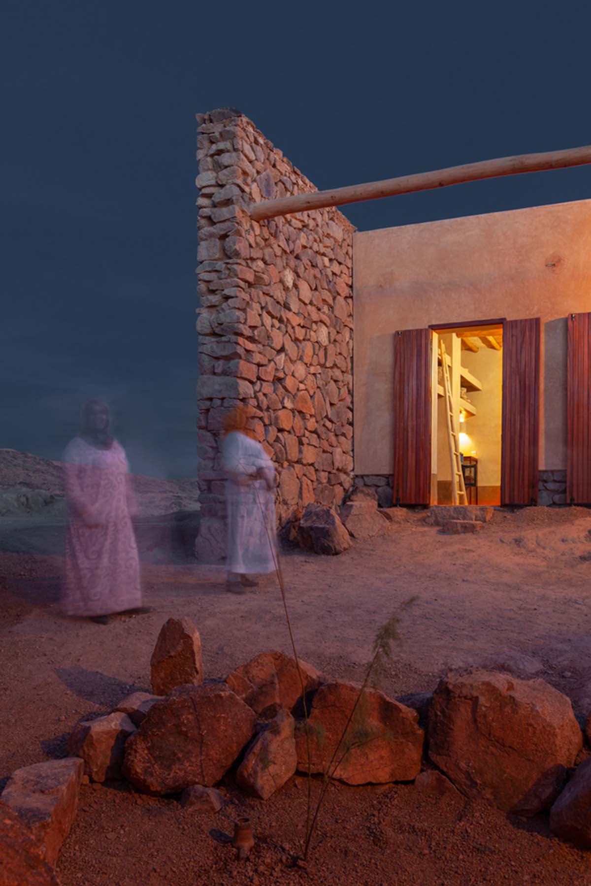 Two elongated walls made of granite rocks and earth form this women's house in a village of Morocco