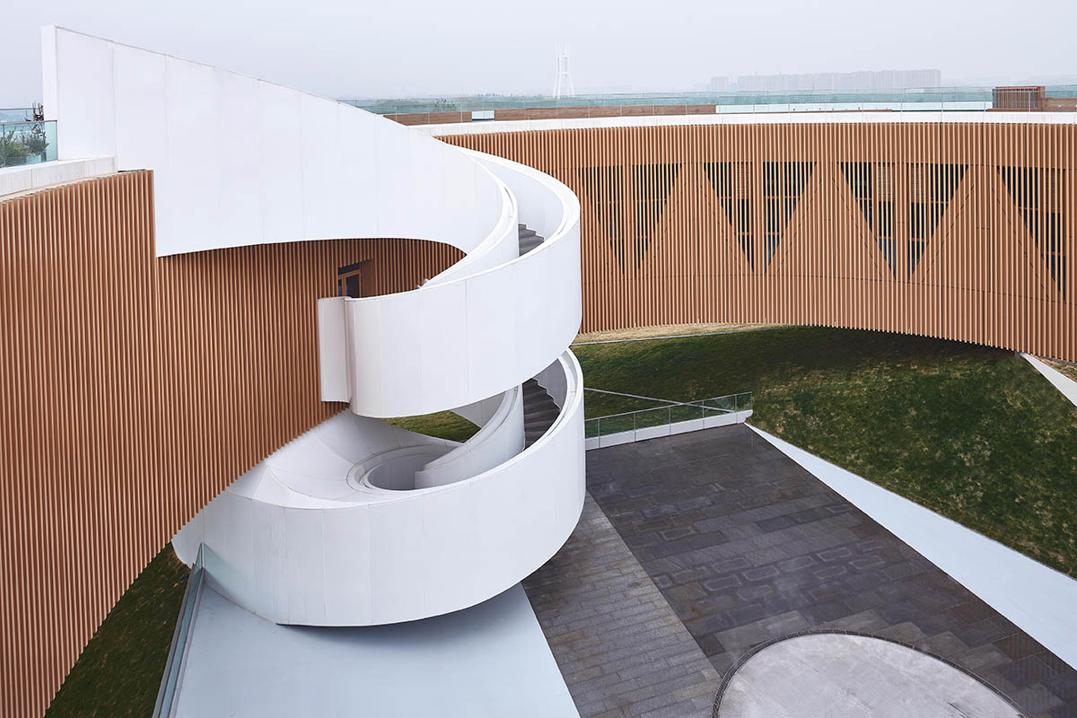 STUDIO A+ designs climbable ring-shaped art center on a green mound in Zhengzhou