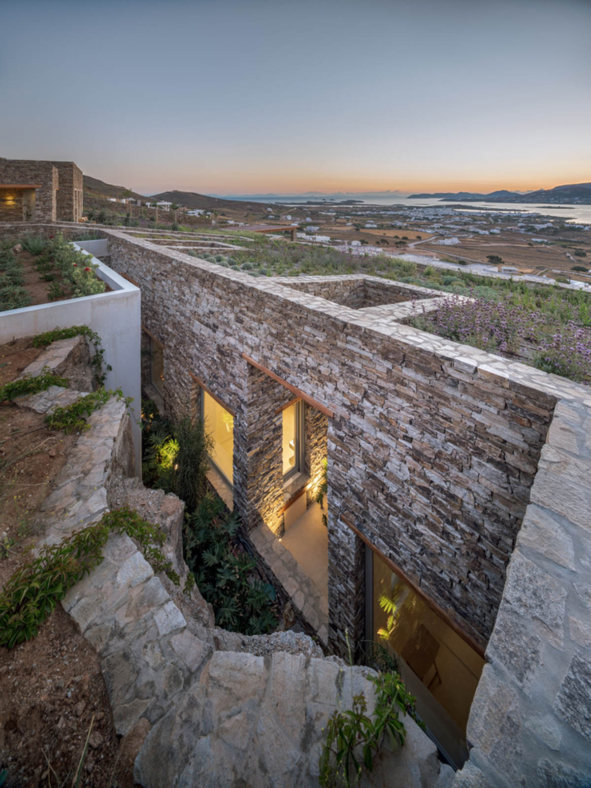 Encaved Stone Villa by Tsolakis Architects mimics natural terrain of steep slope on Paros Island