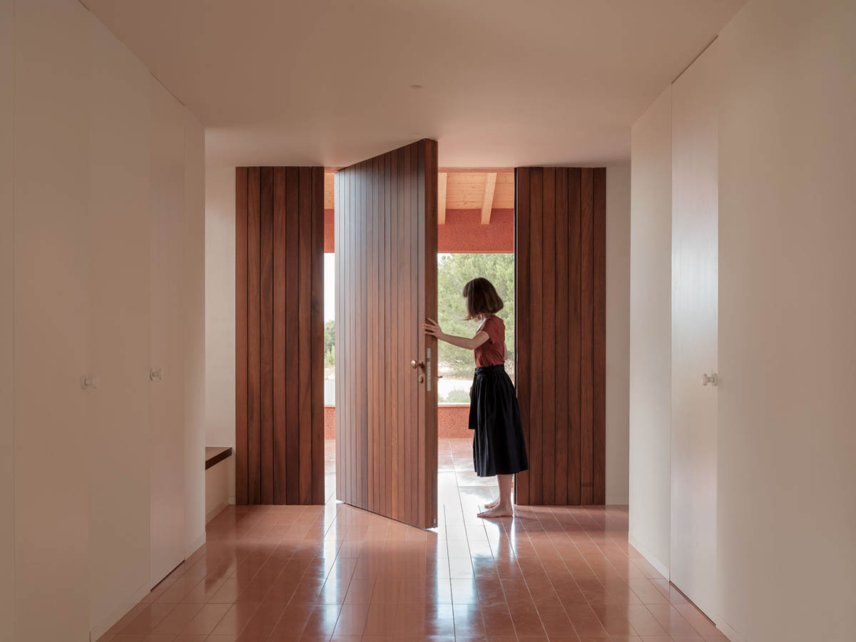 Large openings and reddish-colored façades mark this holiday home by Isla Architects in a rustic land