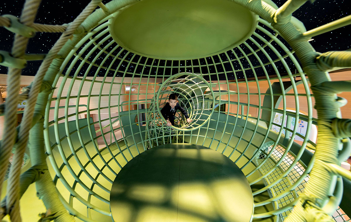 Children's entertainment area by Mind Design mimics green jungle with curvy climbing net in Ningxia 