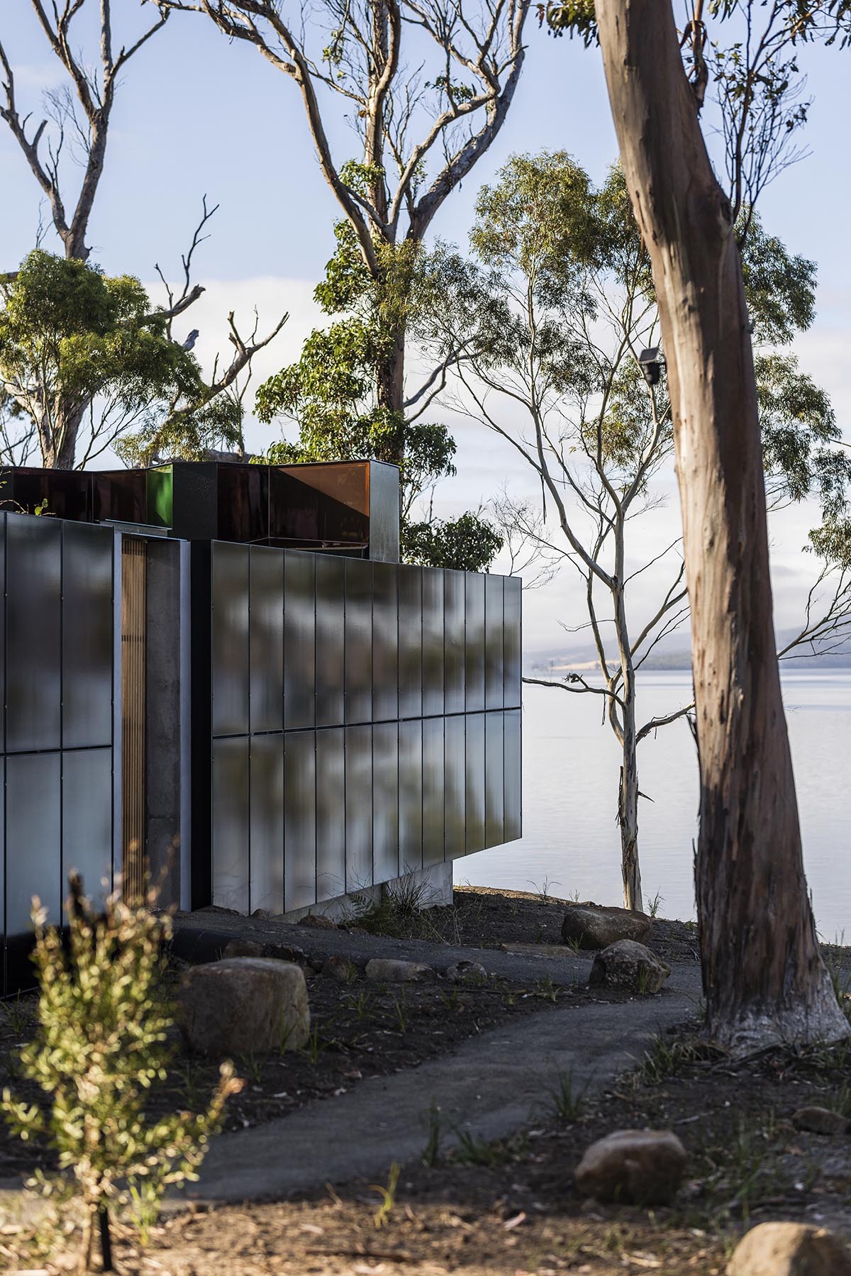 A linear, concrete tunnelled guest house by Room11 architects extends to Tasmania’s bushlands