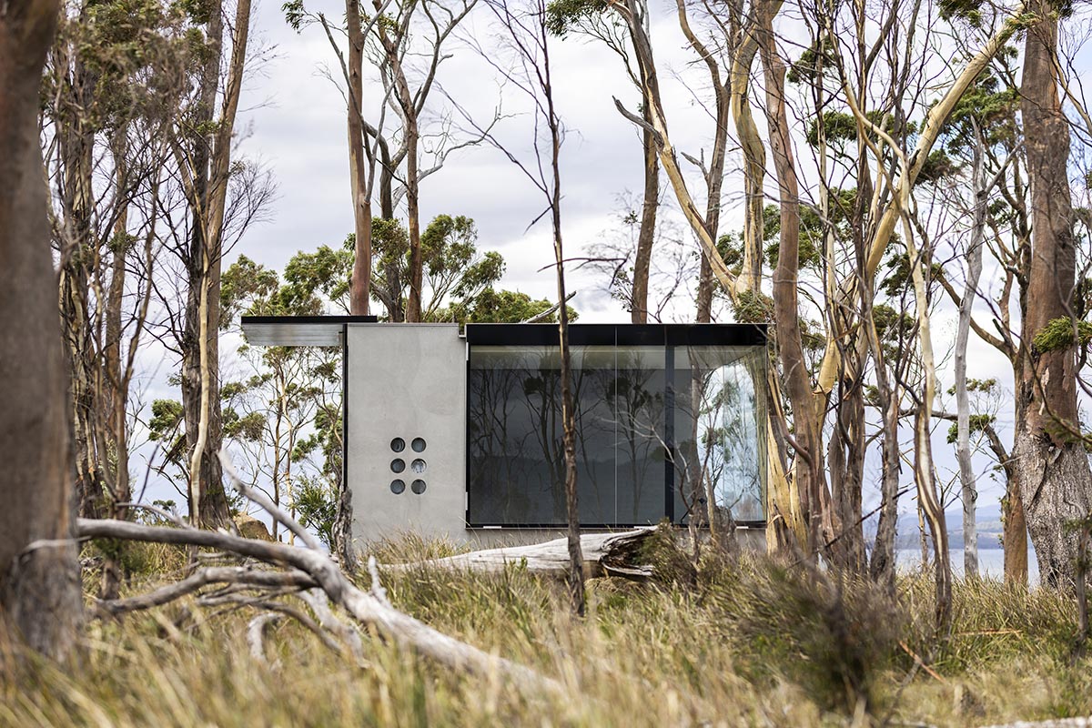A linear, concrete tunnelled guest house by Room11 architects extends to Tasmania’s bushlands
