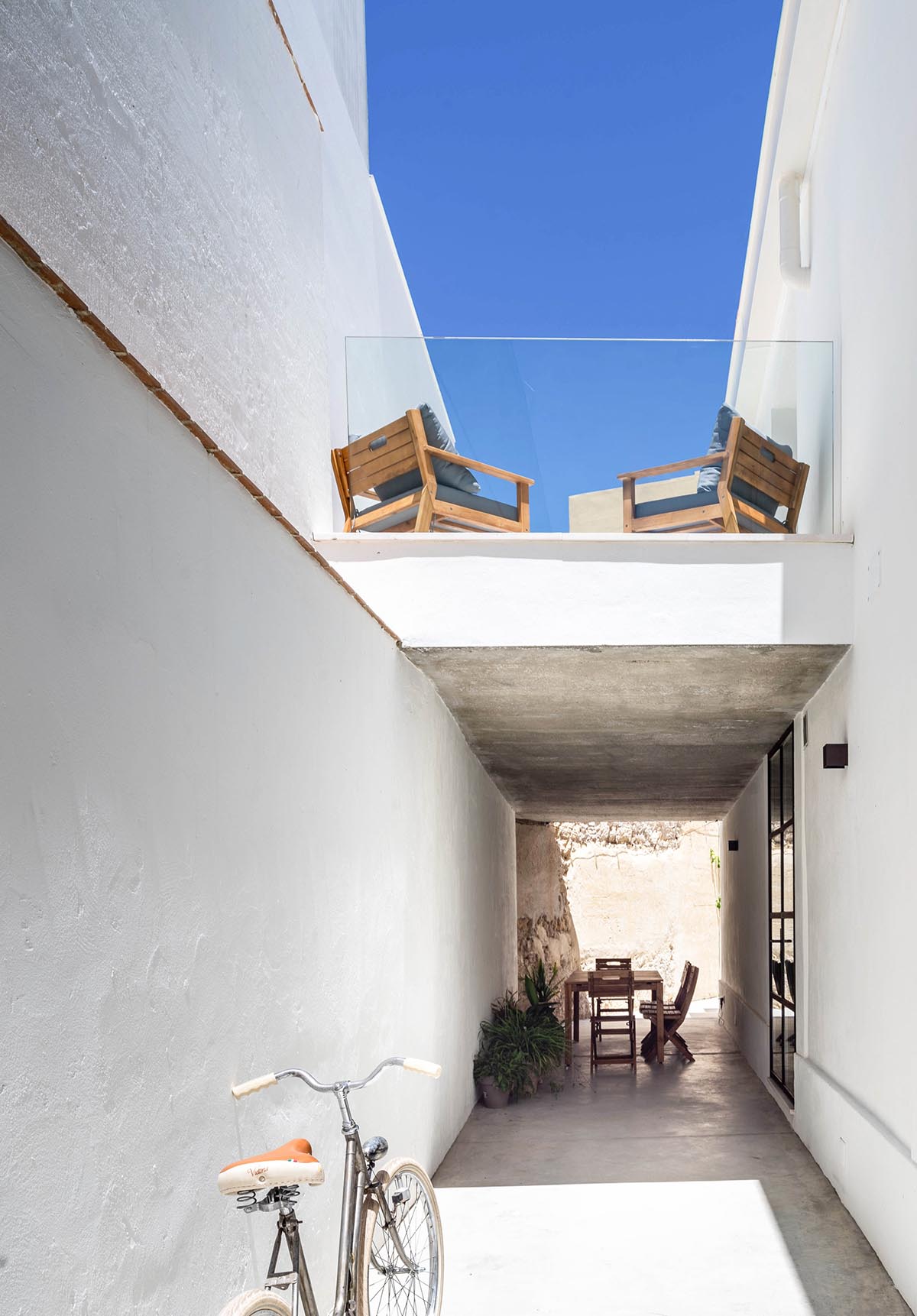 Iniesta Nowell Arquitectos converts old warehouse into house with a network of service alleys