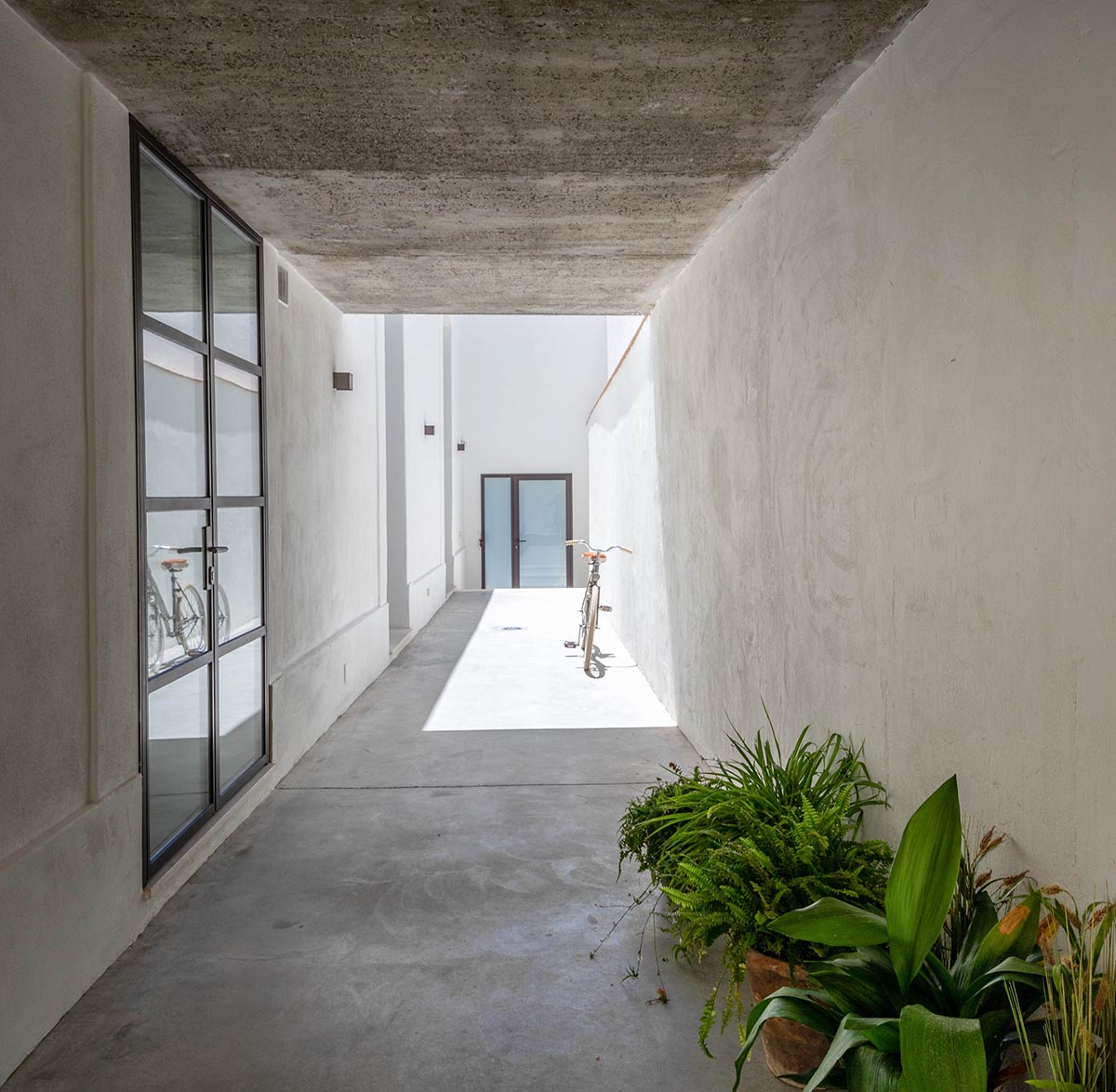 Iniesta Nowell Arquitectos converts old warehouse into house with a network of service alleys