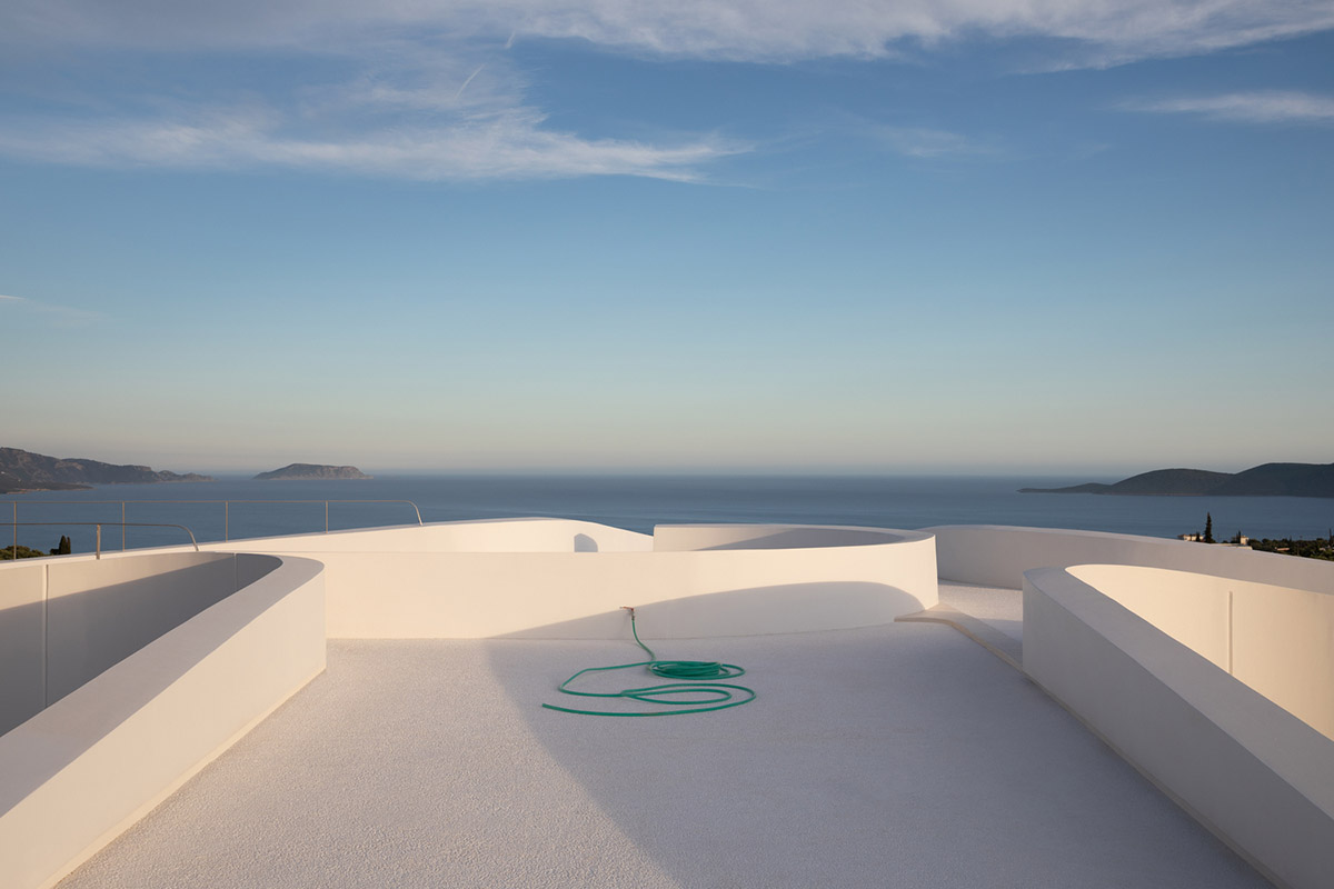 LASSA architects forms rounded walls for house to provide meditative courtyards in Greek olive grove