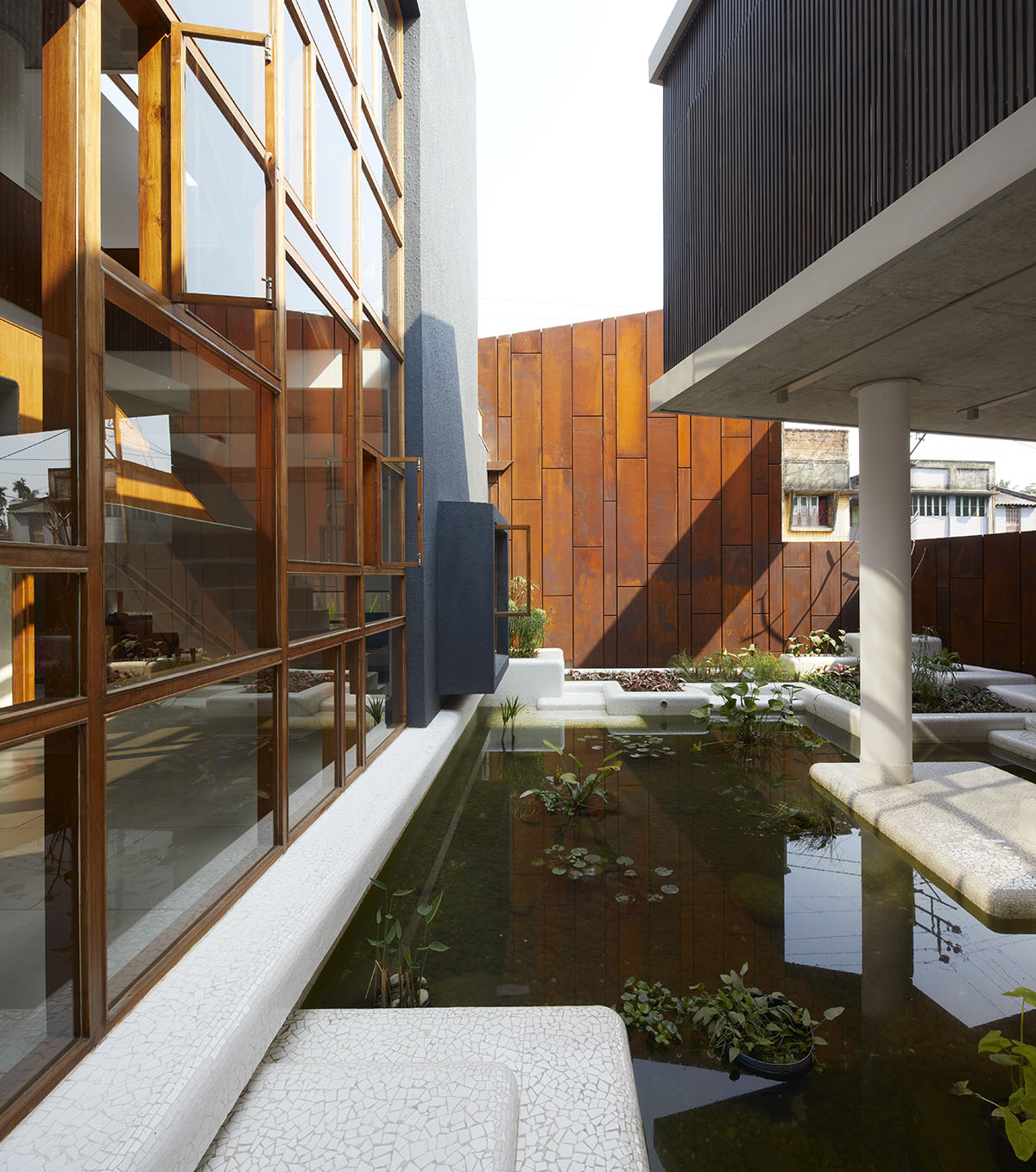 12-foot-tall weathered steel wall ensures privacy and noise-free house in India by Abin Design Studio