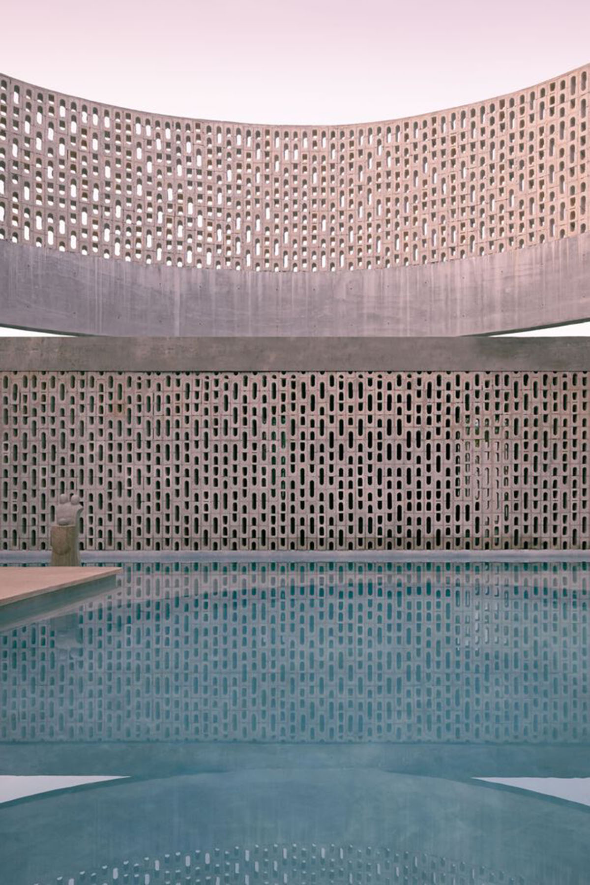 Perforated walls and cylindrical courtyard provide play of light in Wóolis House in Mexico